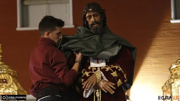 Un hermano coloca un chubasquero a la imagen del Medinacelli