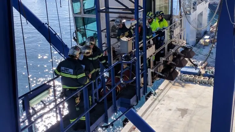 Bomberos en una grua en los muelles