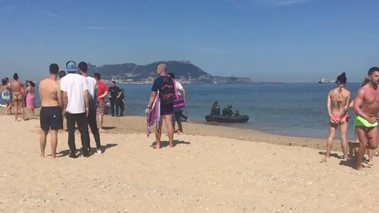 La Guardia Civil y Polic&iacute;a Nacional en la playa junto a la embarcaci&oacute;n retenida