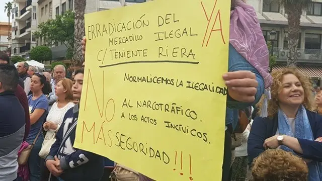 Una vecina porta un cartel contra el mercadillo ilegal en Teniente Riera
