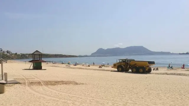Un cami&oacute;n trabajando en la playa, muy cerca de los usuarios