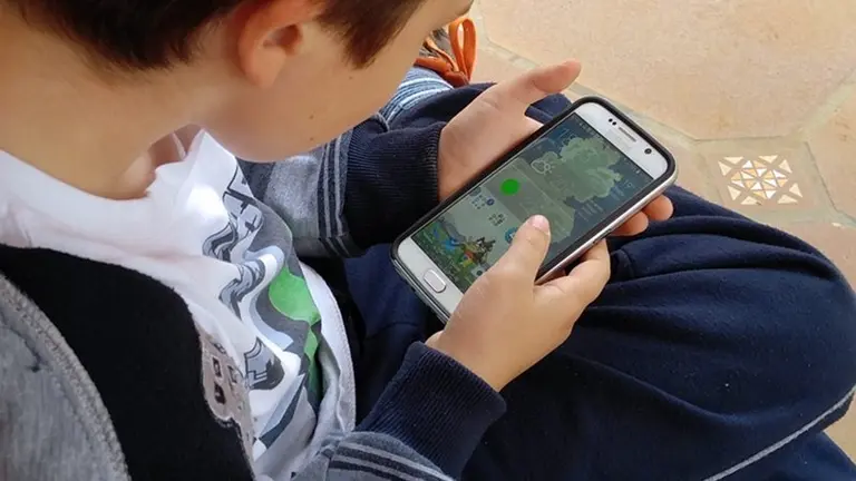 Un menor usando un tel&eacute;fono m&oacute;vil