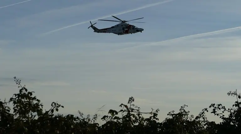 Helic&oacute;ptero sobrevolanbdo la costa en la zona del Faro de Punta Carnero