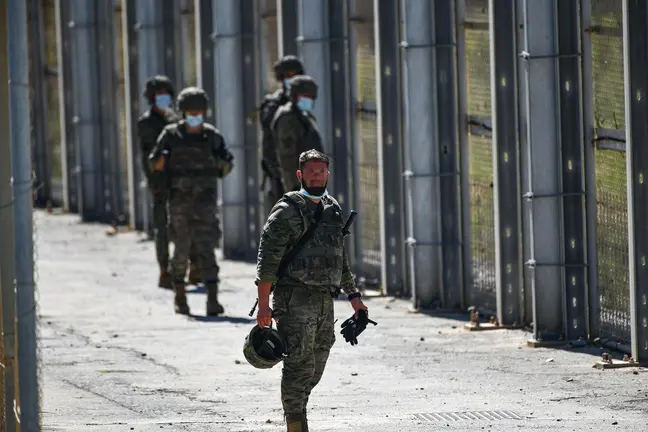 Varios militares vigilan desde la valla que separa Ceuta de Marruecos la llegada de migrantes - Antonio Sempere - Europa Press