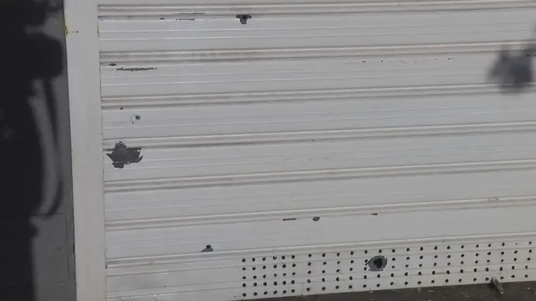 Marcas de bala en la persiana de un local de kebab en el centro
