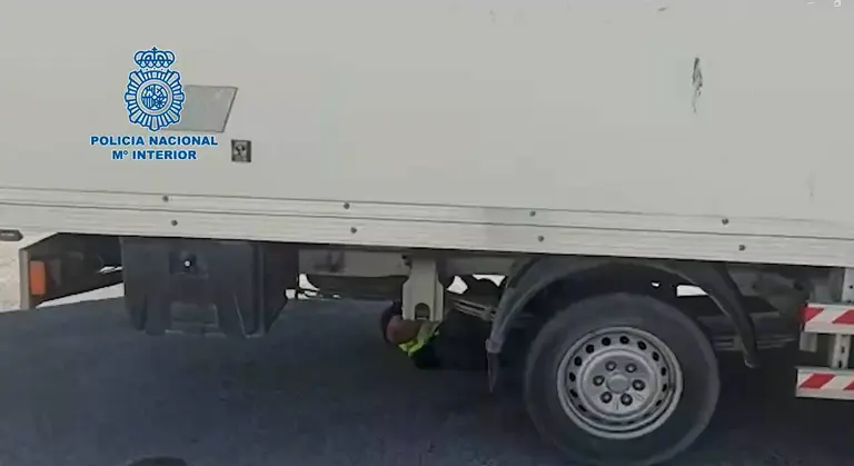 Un polic&iacute;a inspecciona los bajos de uno de los camiones interceptrados