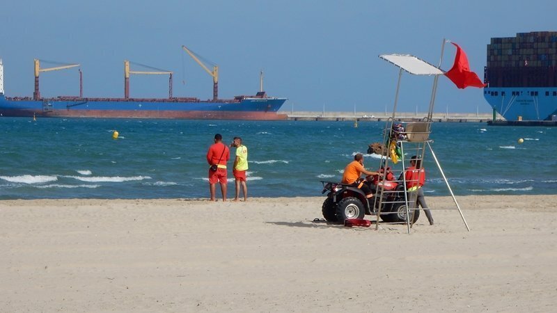 Socorristas con bandera roja en la playa del Rinconcillo