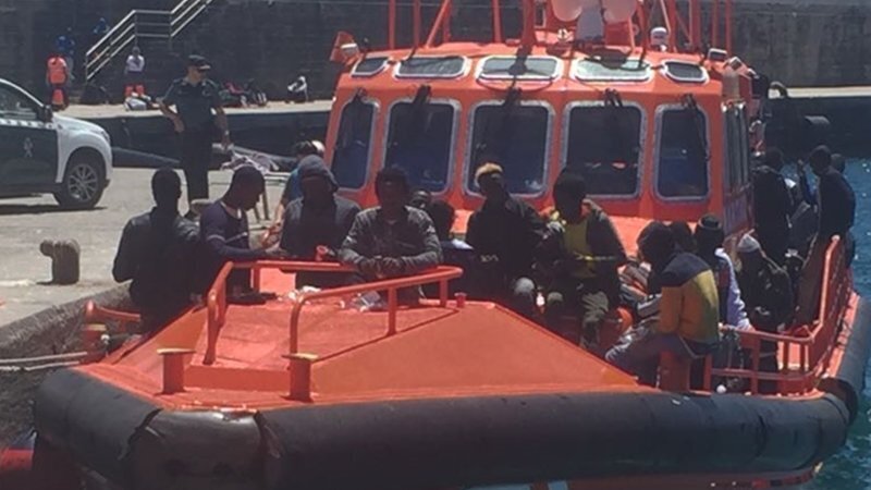 Inmigrantes embarcados, vigilados por la Guardia Civil