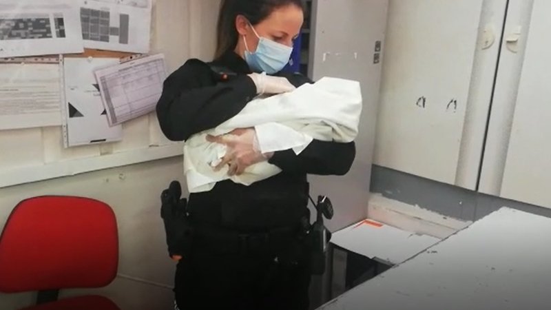 Una agente con el bebé en brazos