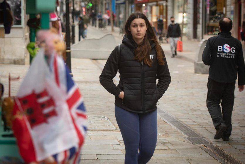 Una chica camina sin mascarilla por Gibraltar